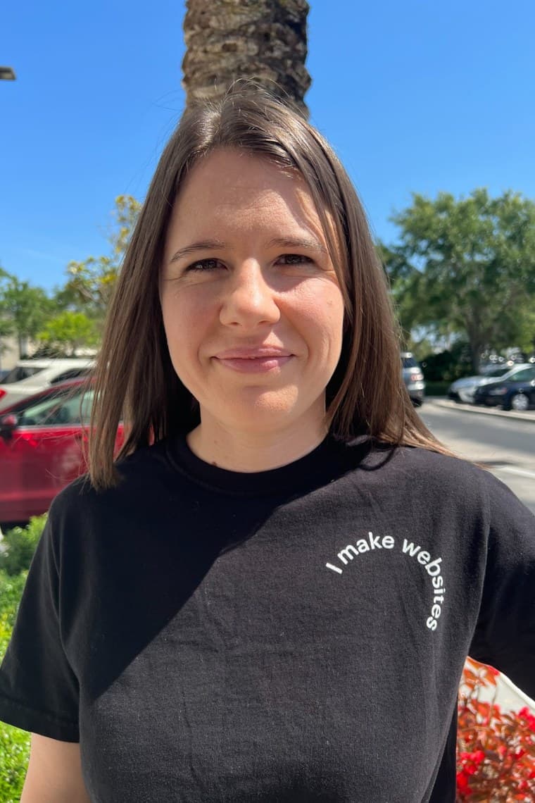 Jen Ross, founder of Mercury Jane, smiling outdoors in Mount Dora wearing a black t-shirt that reads 'I make websites'