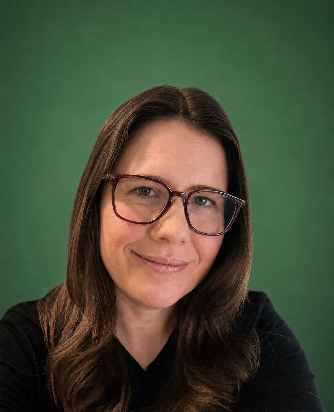 Headshot of Jen Ross, founder of Mercury Jane, wearing glasses and a black top against a verde green backdrop